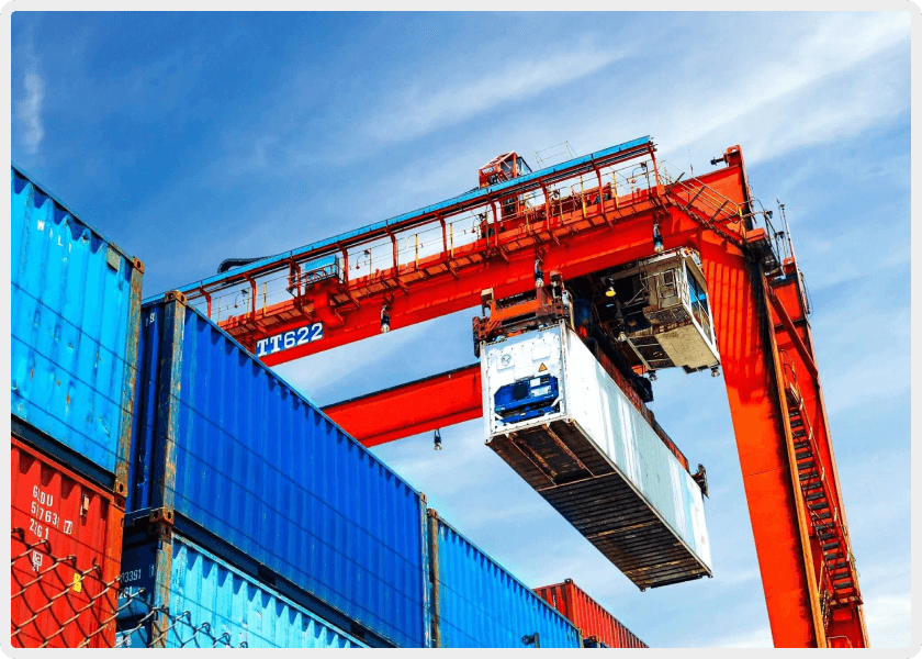 A crane is lifting a container in the air.