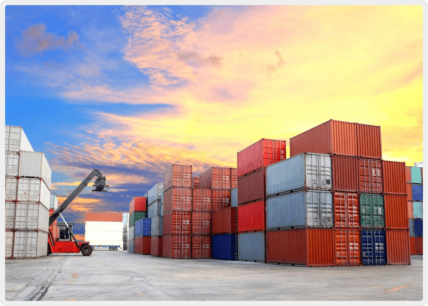 A crane is lifting cargo containers in an industrial area.